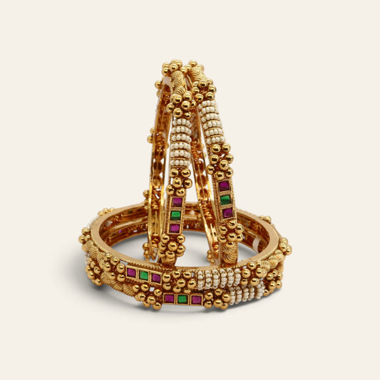 Pearl and red-green stone studded bangle set shown with a wooden jewellery box