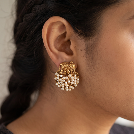 Model wearing elephant motif gold-plated pearl cluster stud earrings, traditional Maharashtrian temple jewellery