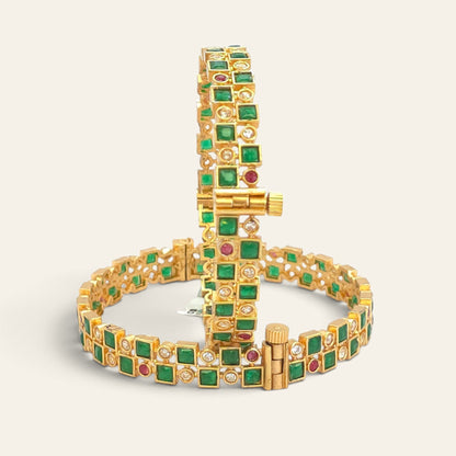 Emerald green gold plated bangle displayed upright on stand with second bangle in background