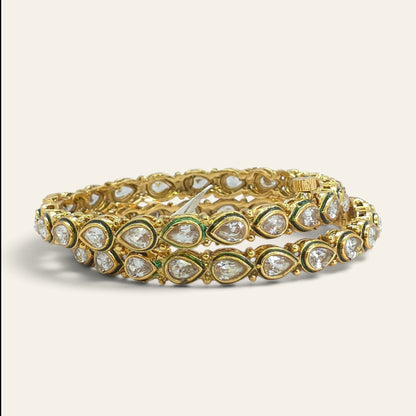 Pair of white kundan gold plated bangles standing upright, front view