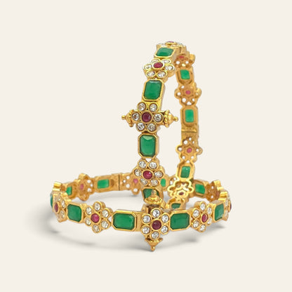 Emerald green floral ruby gold plated bangles, pair standing upright angled view