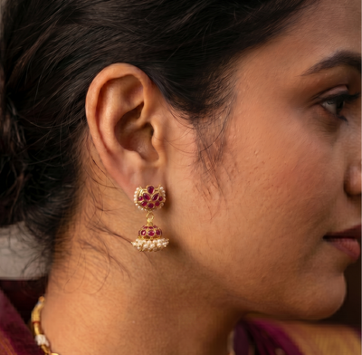 Close-up of a woman wearing traditional jewelry including earrings and a necklace.