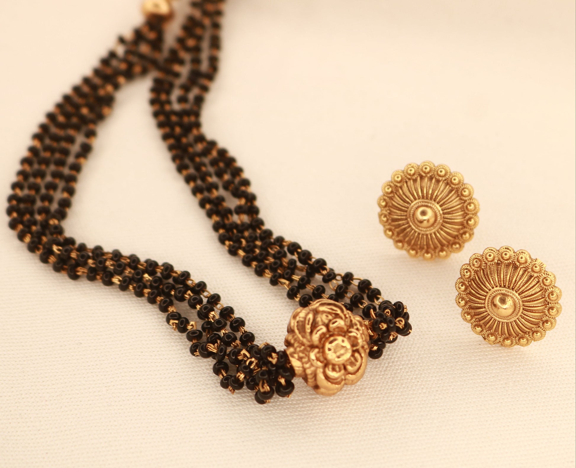 Short 10 inch black bead mangalsutra with circular gold stud earrings for festive and bridal wear