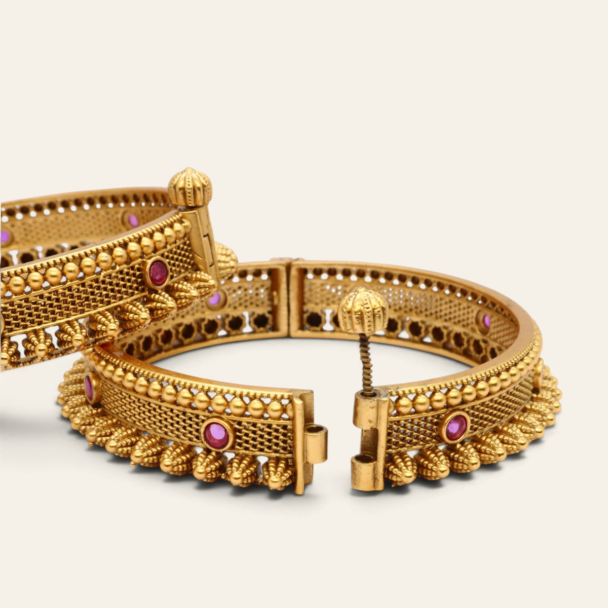 Openable screw kada bangles in antique gold plated finish with red stones