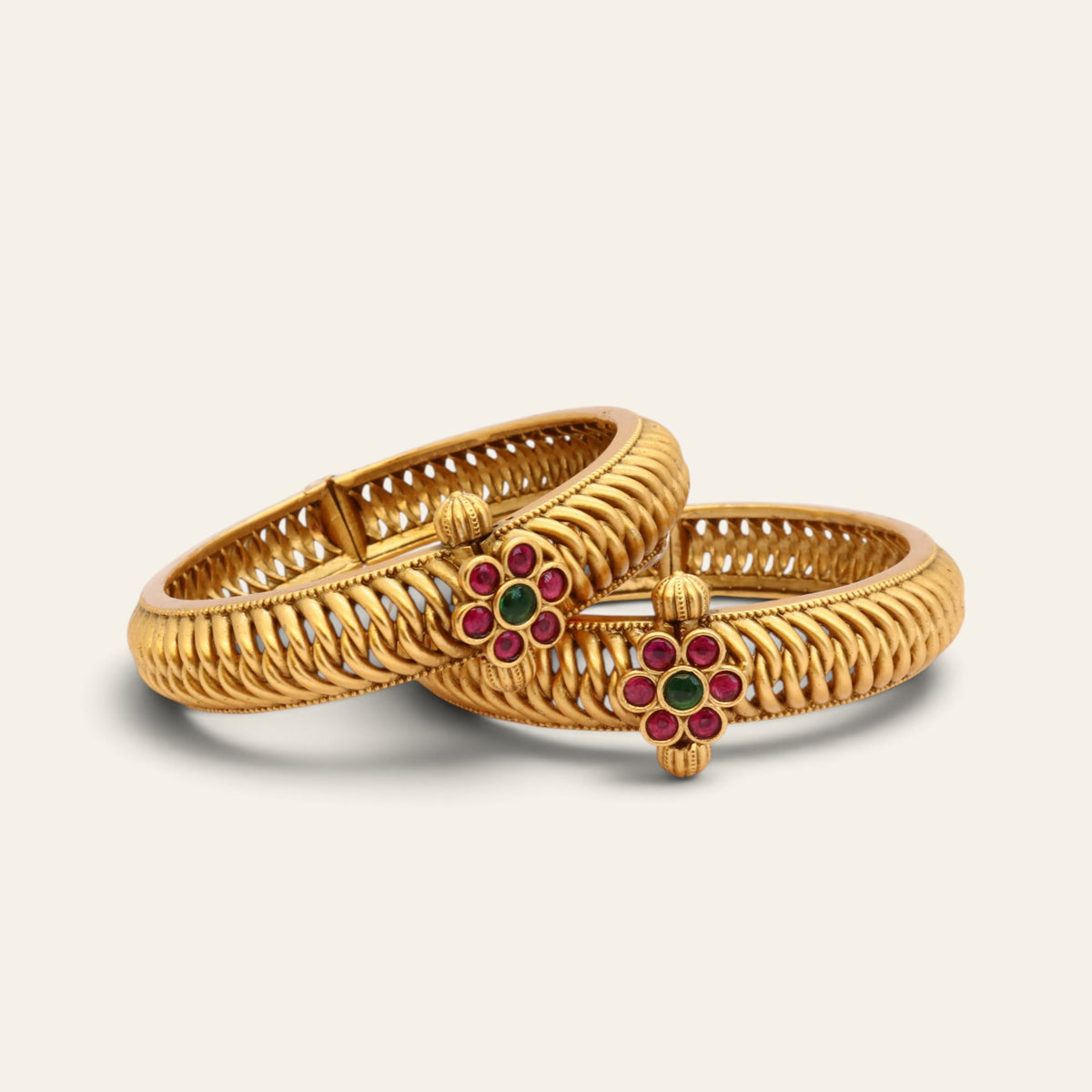 Red and green floral kundan gold-plated kada bangles with twisted openwork, pair