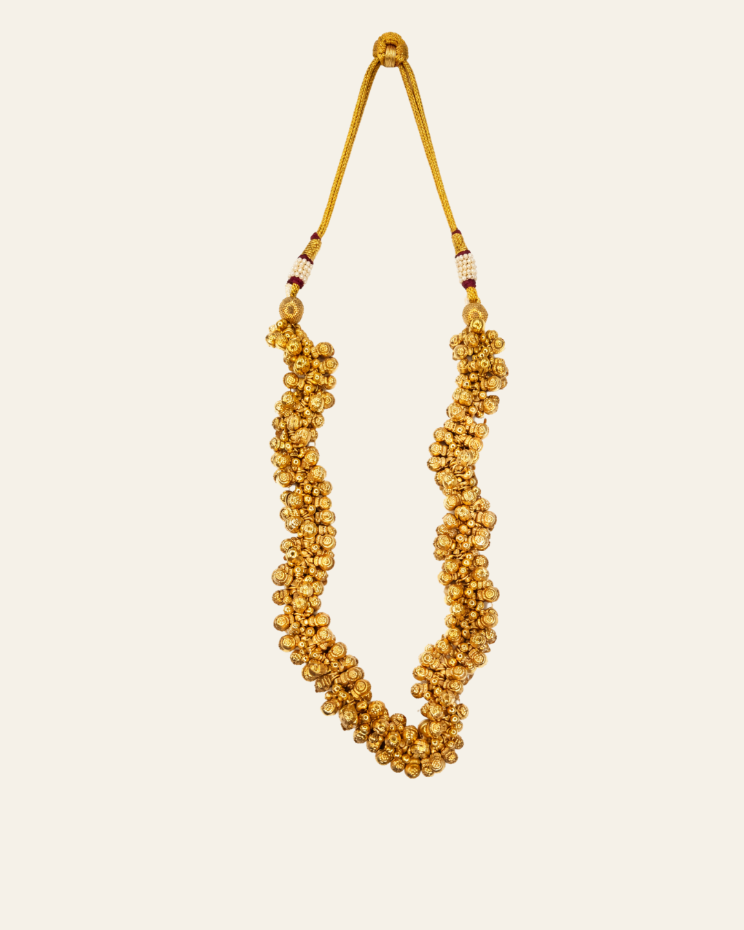 Gold plated ghungru necklace hanging on adjustable gold braided dori, showing 14 inch drop length