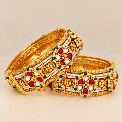 Close-up of gold plated kundan bangle with ruby-red and white polki stones, seed pearls and green beads