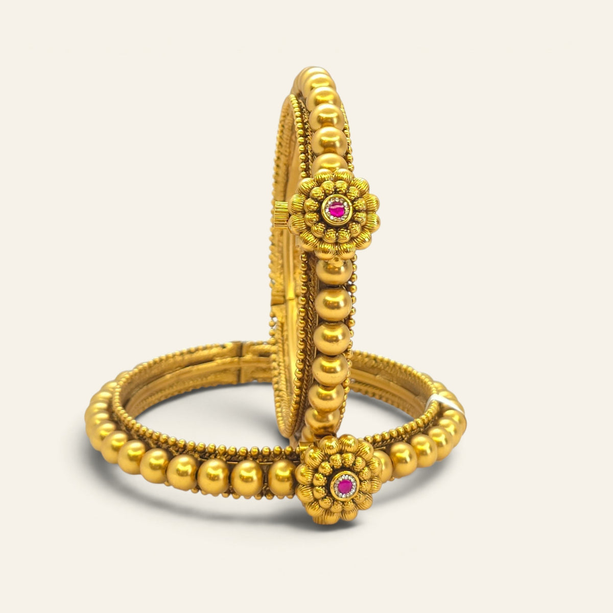 Close-up of Thushi-inspired gold-plated bangle with floral centre detail
