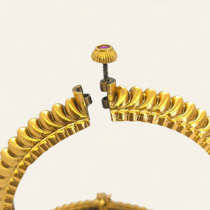 Two gold-plated Shindeshahi Tode bangles displayed upright with red stone accents