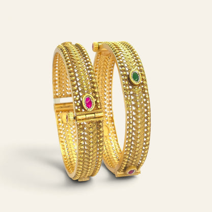 Antique gold plated Kada bangles with ruby and emerald stones, angled view showing screw fitting closure