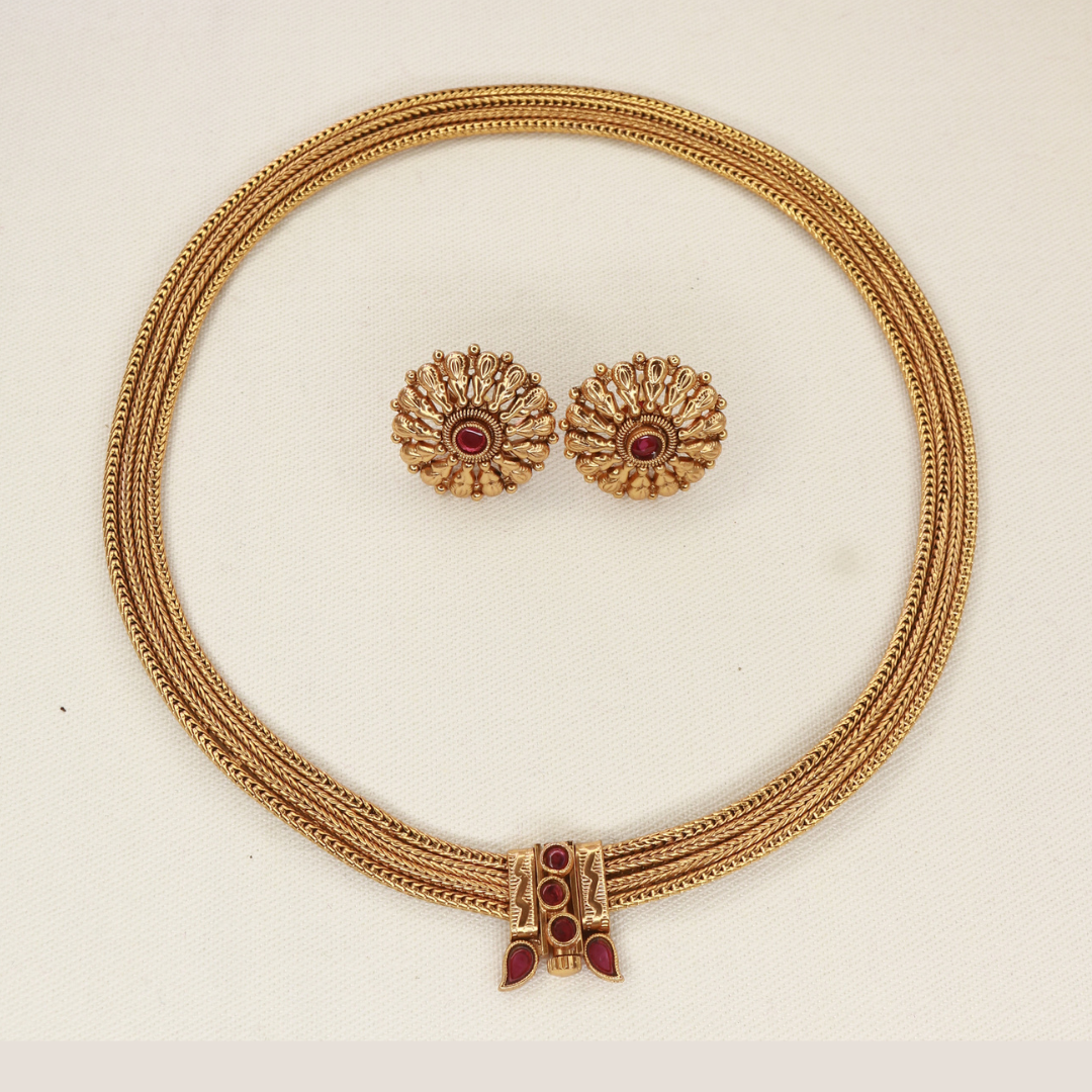 Close-up of Chitaag necklace front clasp with ruby red stones in round and teardrop settings