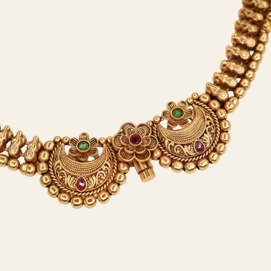 Close-up of Chandbali choker necklace twin crescent moon pendants with ruby and emerald stones and gold bead border