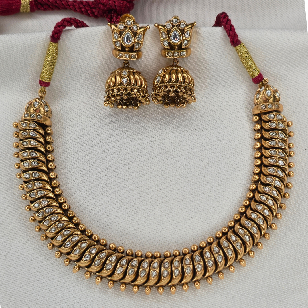 Shinde Shahi antique gold necklace close-up showing gemstone leaf motifs