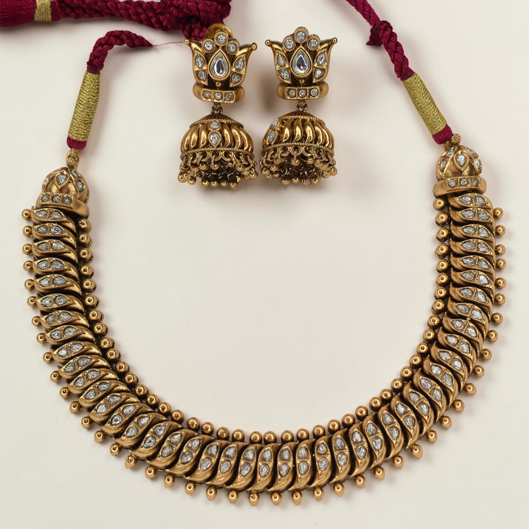 Shinde Shahi antique gold necklace close-up showing gemstone leaf motifs