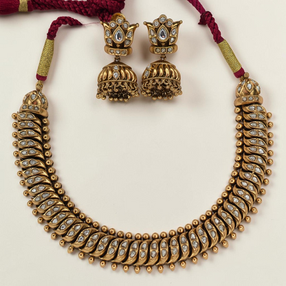 Shinde Shahi antique gold necklace close-up showing gemstone leaf motifs