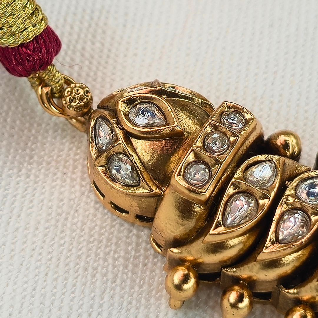 Shinde Shahi antique gold Jhumka earrings side view on stand