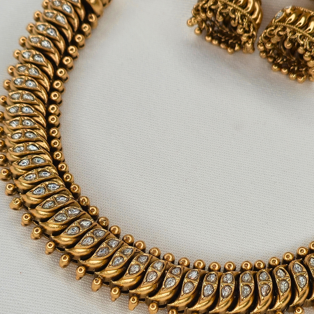 Shinde Shahi antique gold necklace detail with Jhumka earrings in background