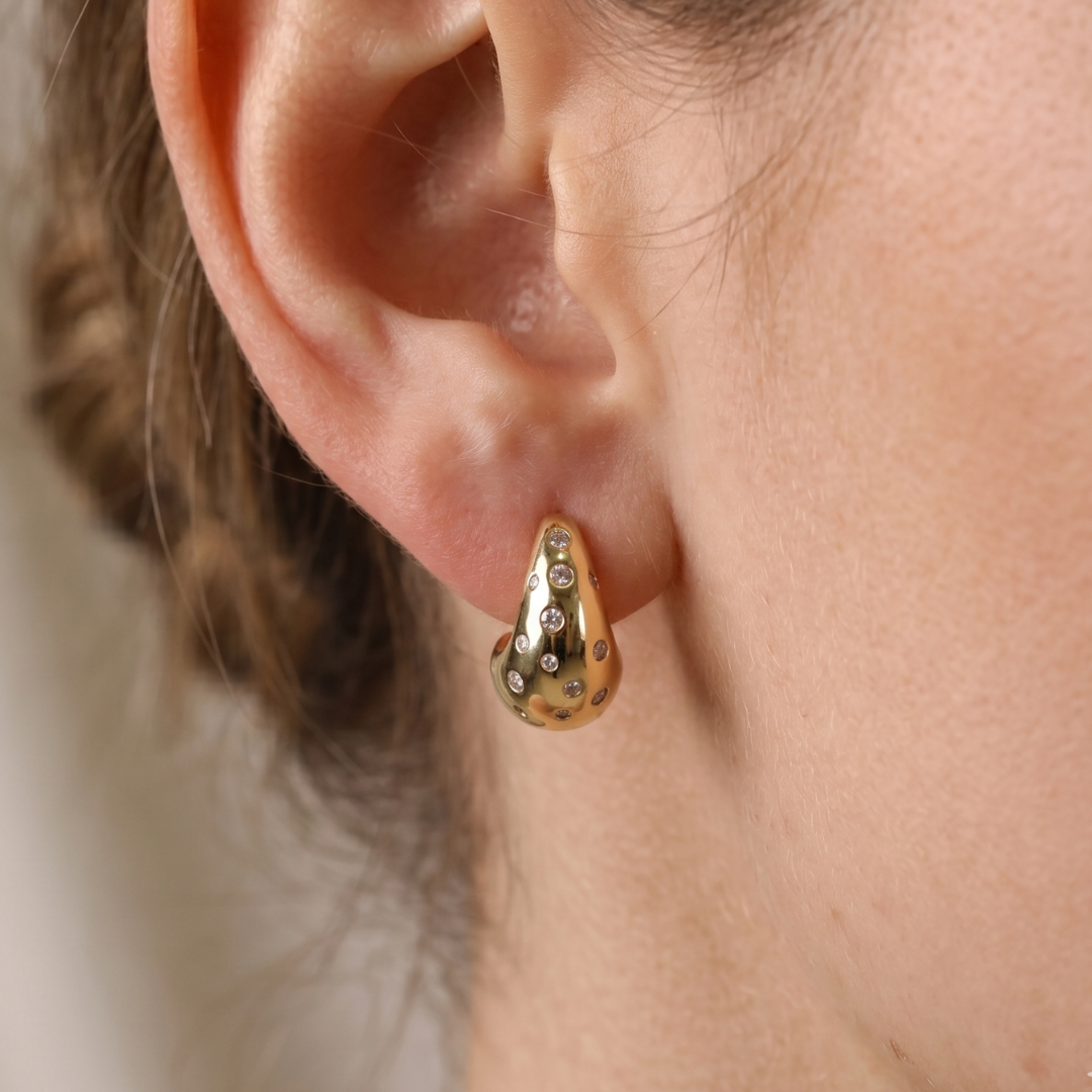 Chunky gold-plated dewdrop hoop earrings with celestial cubic zirconia scatter setting, close-up