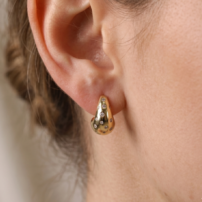 Chunky gold-plated dewdrop hoop earrings with celestial cubic zirconia scatter setting, close-up