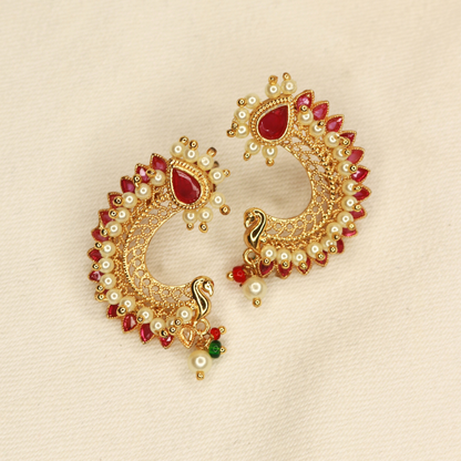 Close-up of peacock motif ruby pearl gold-plated earrings with red stone border and pearl drop, Jija Jewellery