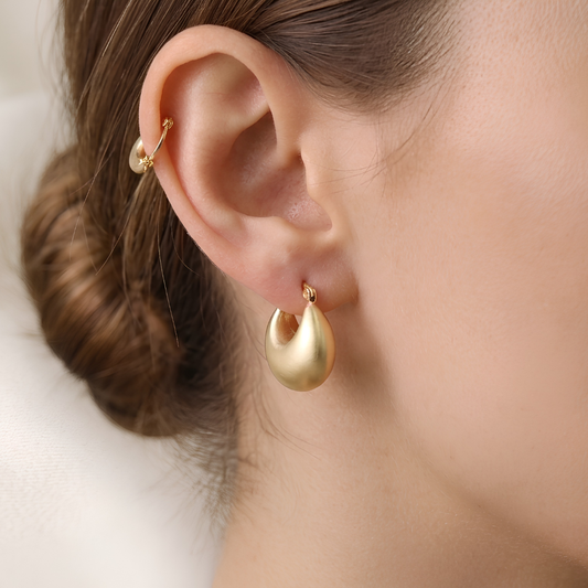 Model wearing matte gold chunky teardrop dome hoop earring, anti-tarnish dewdrop drop by Jija Jewellery