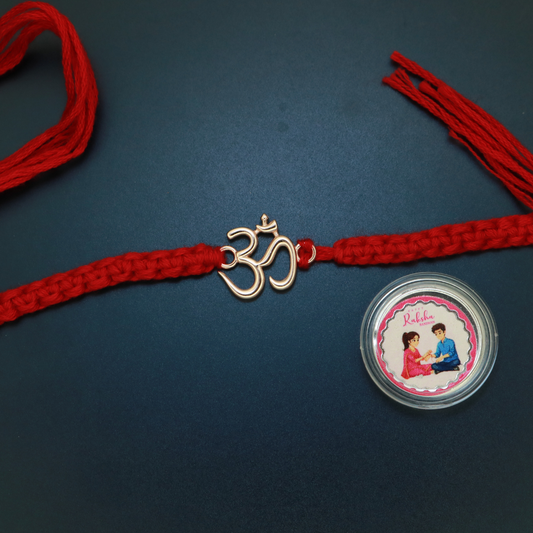Rose gold plated sterling silver Om rakhi in classic open outline on braided red thread