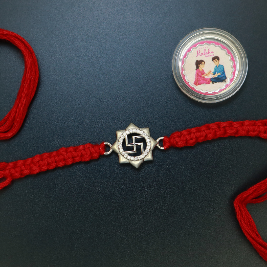 Sterling silver Swastik rakhi set in an eight-petal lotus frame with zircon on red thread