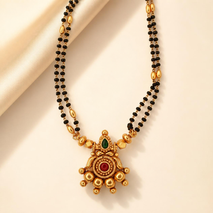 Close-up of emerald ruby star pendant mangalsutra with double strand black bead chain and antique gold plated beads – Jija Jewellery
