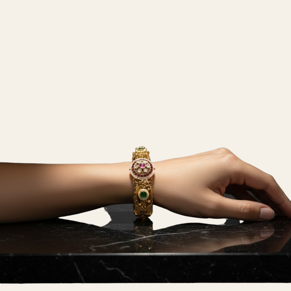 Jija Jewellery gold plated Rajwada Kundan Kada bangle with red and green stones worn on a wrist against dark background