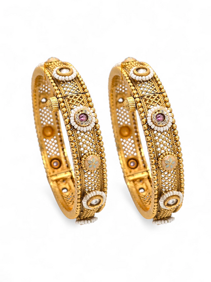 Pair of gold plated mesh bangles with kundan stones on white background