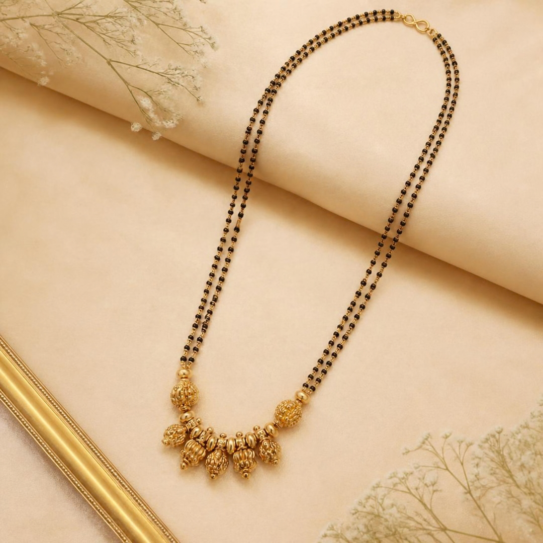 Full-length view of long double strand black bead mangalsutra with antique gold Lakshmi temple pendant beads, traditional wedding jewellery