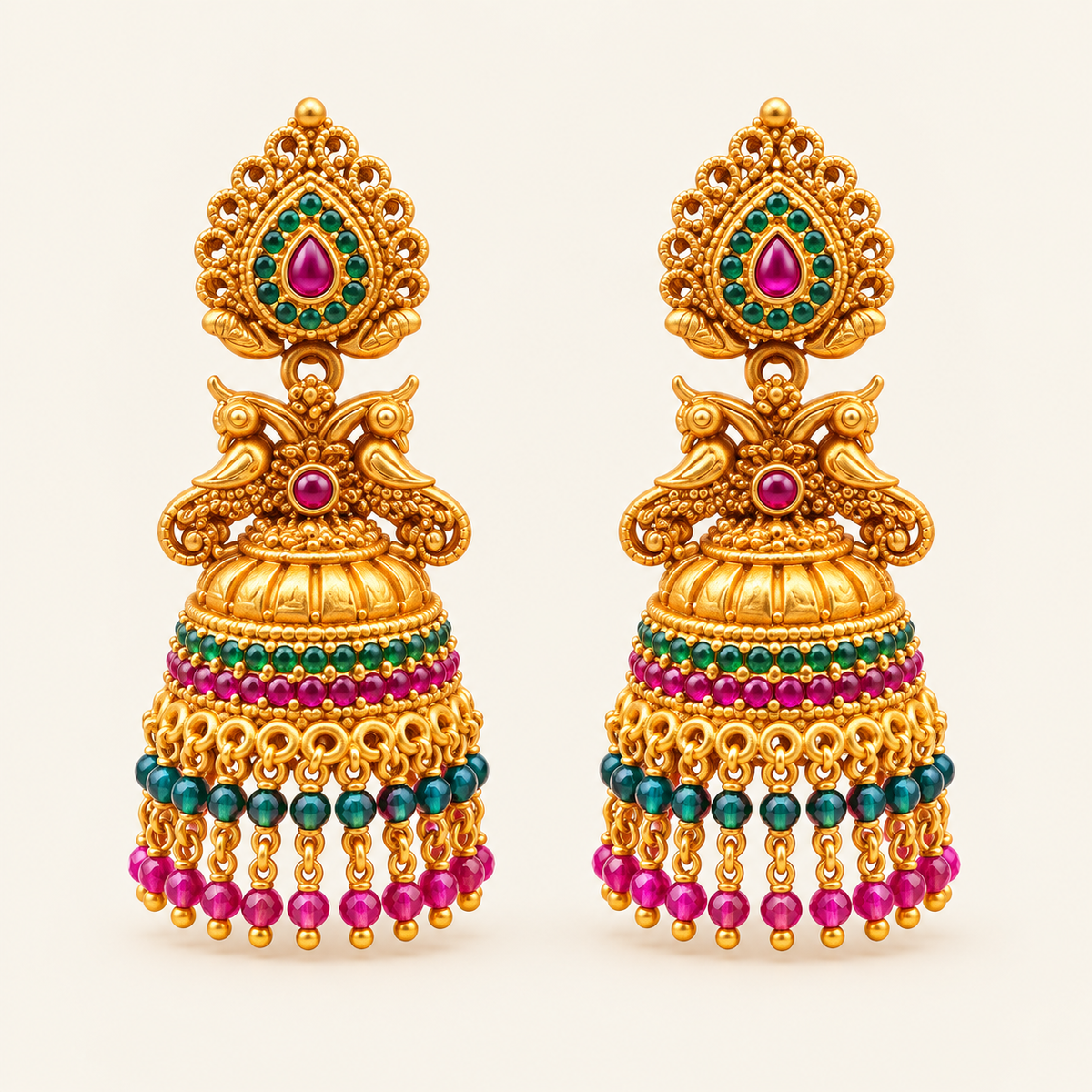 Pair of gold-plated peacock jhumkas with pink and green stones and dangling bead tassels