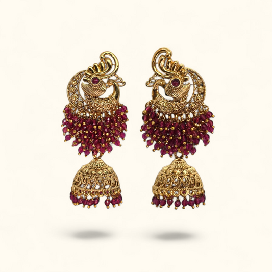 Gold plated peacock zumka with red crystal bead cluster and jhumka drop on white background