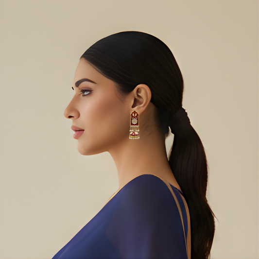 Side profile of woman wearing red meena zumka earrings with blue saree