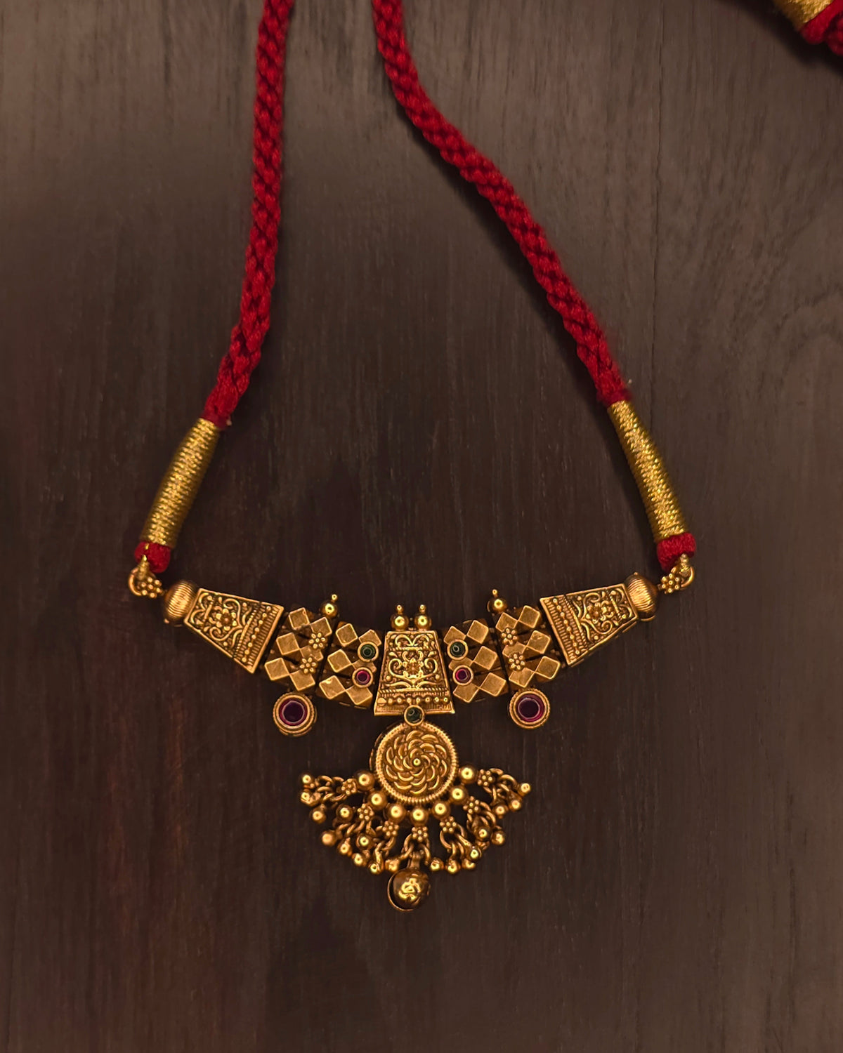Traditional Maharashtrian Thushi necklace in antique gold plating with fan-shaped pendant, ruby-red stones and red dori with tassel – Jija Jewellery